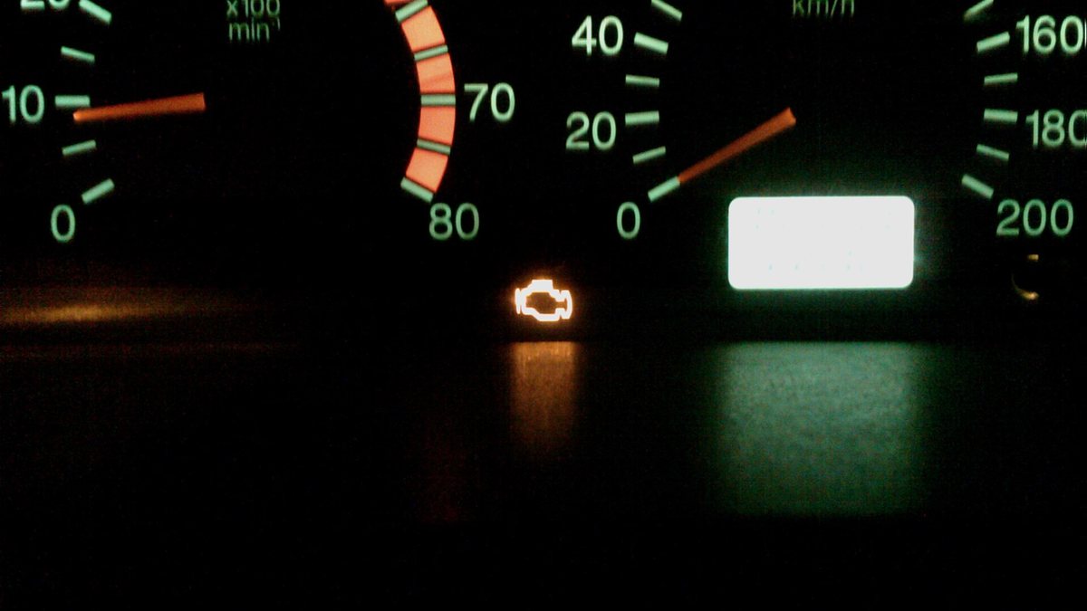 Приборная панель автомобиля ночью с горящей желтой лампой Check Engine